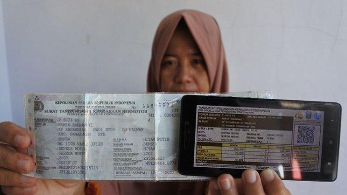 Ilustrasi - Seorang warga memperlihatkan bukti pelunasan pajak kendaraan bermotor yang dibayar secara daring atau online dari rumah di Panarukan, Situbondo, Jawa Timur, Kamis (26/3/2020). Pembayaran secara online itu karena diliburkannya pembayaran secara langsung melalui Samsat untuk mencegah penularan Covid-19.