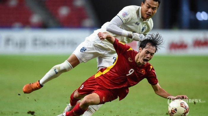 Chatchai Bootprom (kiri) dari Timnas Thailand berebut bola dengan Nguyen Van Toan dari Vietnam pada pertandingan leg pertama semifinal sepak bola AFF Suzuki Cup 2020 antara Timnas Vietnam dan Timnas Thailand di National Stadium di Singapura pada 23 Desember 2021. (Roslan RAHMAN/AFP)