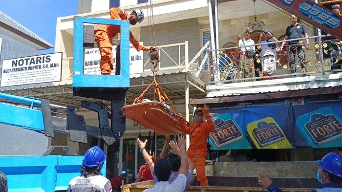 Petugas Basarnas saat mengevakuasi Made Widi dari rumahnya yang terletak di Kelurahan Banyuasri, Kecamatan Buleleng menggunakan mobil sky lift untuk mendapatkan penanganan medis, Senin (17/7) pagi.