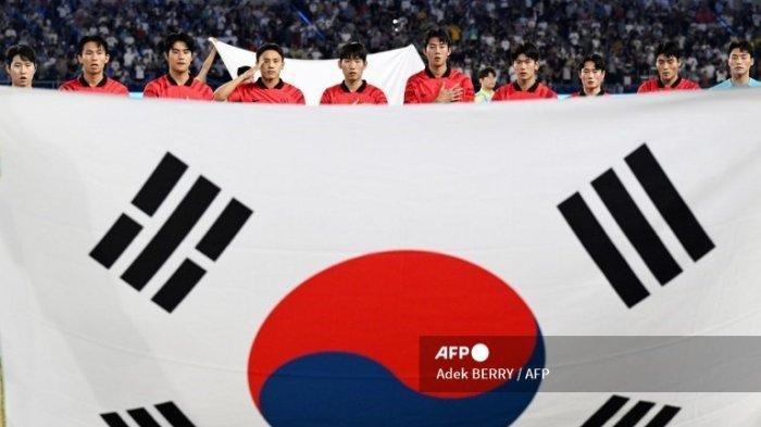 Para pemain Korea Selatan berdiri di belakang bendera nasional negara tersebut saat mereka mendengarkan lagu kebangsaan mereka pada pertandingan sepak bola semifinal putra antara Korea Selatan dan Uzbekistan pada Asian Games 2022 di Hangzhou di provinsi Zhejiang timur Tiongkok pada 4 Oktober 2023.