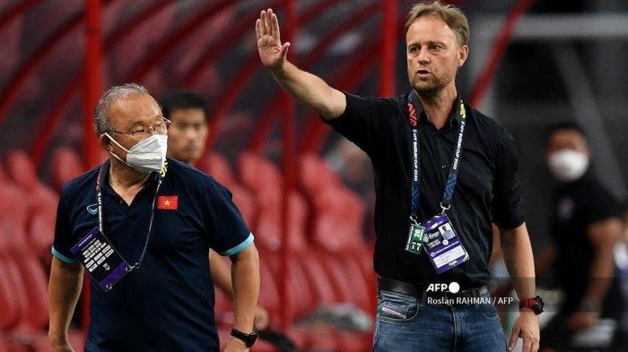 Pelatih kepala Thailand Alexandre Polking (kanan) memberi isyarat di samping pelatih Vietnam Park Hang-seo selama leg kedua pertandingan semifinal sepak bola AFF Suzuki Cup 2020 antara Vietnam dan Thailand di National Stadium di Singapura pada 26 Desember 2021.