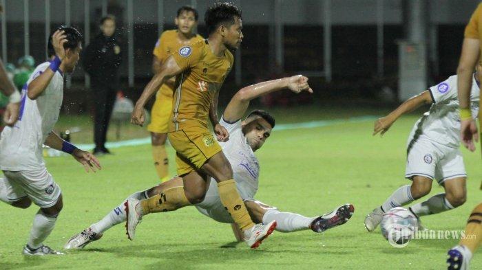 Pesepak bola Arema FC, Fabiano Beltrame (bawah) melakukan tekel kepada pesepak bola Bhayangkara FC, Andik Vermansyah yang sedang menggiring bola pada pekan 18 BRI Liga 1 2021-2022 di Stadion Kompyang Sujana, Denpasar, Bali, Minggu (9/1/2022). Arema FC memenangkan pertandingan 1-0 berkat gol Rizky Dwi Febrianto pada menit ke-20.