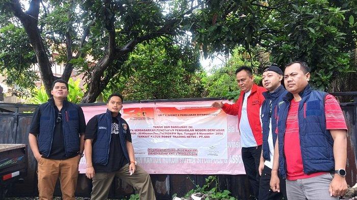 Proses pemasangan stiker besar sebagai tanda bahwa bangunan dan tanah disita oleh Bareskrim Polri.