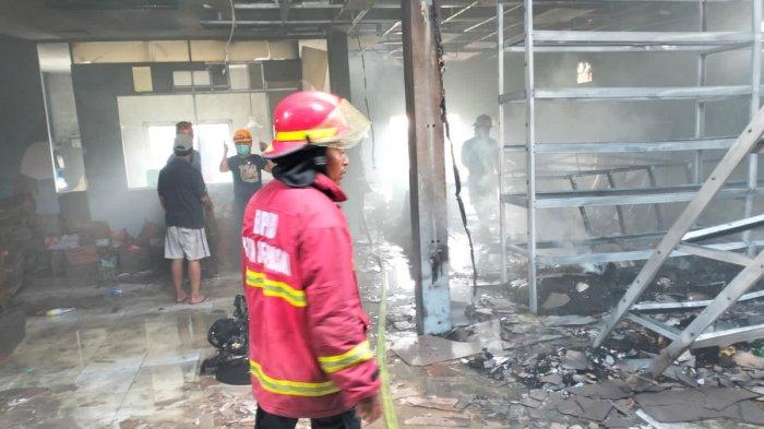 Suasana saat pemadam kebakaran memadamkan api di Toko Nadi Ayu, Jalan Kebo Iwa Utara Denpasar.