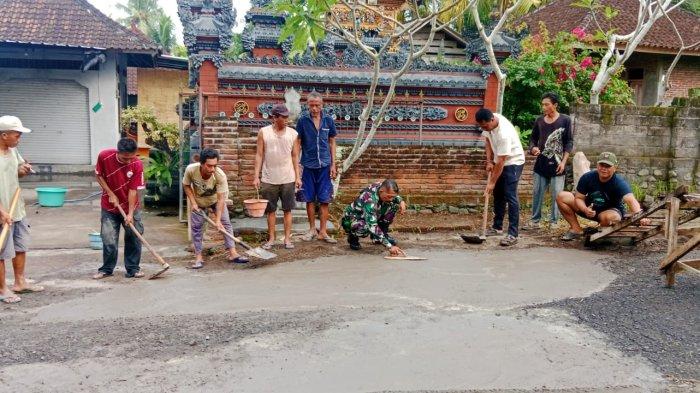 GOTONG ROYONG - Warga Banjar Kepuh, Desa Mendoyo Dauh Tukad, Kecamatan Mendoyo, Jembrana, gotong royong menambal jalan rusak, Minggu (2/6). Mereka muak karena jalan tersebut rusak sejak lama namun tak kunjung ada perbaikan.