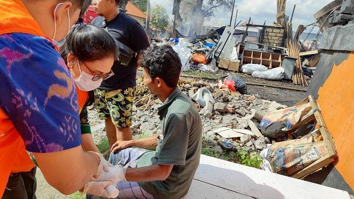 KORBAN KEBAKARAN - Petugas memberi perawatan kepada korban kebakaran di Jalan Pura Banyu Kuning, Desa Padangsambian Kelod, Denpasar Barat, Selasa (15/10)