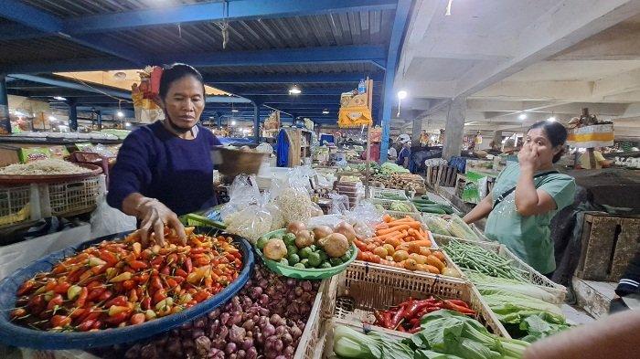 Layani pembeli - Pedagang sayur dan bumbu dapur di Pasar Kidul, Ni Ketut Sutriani, saat melayani pembeli. Diketahui harga tomat hingga bulan Mei masih tergolong tinggi. Sedangkan harga cabai rawit merah turun drastis, yakni di harga Rp 30 ribu per kilo.