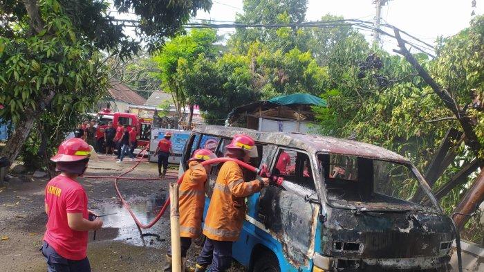 Petugas pemadam kebakaran sedang memadamkan api yang membakar mini bus isuzu, Selasa (1/5/2024) sore.