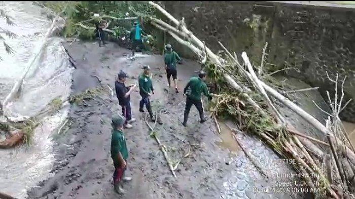 Petugas dinas PUPR Perkim Bangli ketika melakukan upaya pembersihan material longsor di bendung Sidembunut Kanan. Senin (10/7/2023).