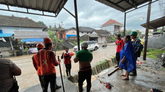 BANJIR - Dinas PUPR Badung saat membersihkan gelondongan kayu, yang menyumbat saluran irigasi hingga membuat air meluap di Desa Sembung pada Kamis 27 Maret 2025.