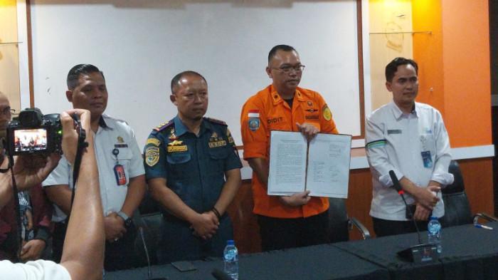 DITUTUP – Perwakilan Kantor SAR, ASDP Indonesia Ferry Cabang Ketapang, dan Kementerian Perhubungan yang diwakili KSOP Tanjung Wangi Berita menunjukkan berita acara penutupan operasi SAR KMP Tunu Pratama Jaya di ruang rapat Kantor ASDP Indonesia Ferry Cabang Ketapang, Senin (21/7).