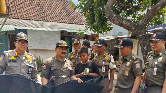 TURUNKAN LAYANGAN - Satpol PP Badung saat menurunkan layangan di wilayah Kedonganan, Selasa (30/7).