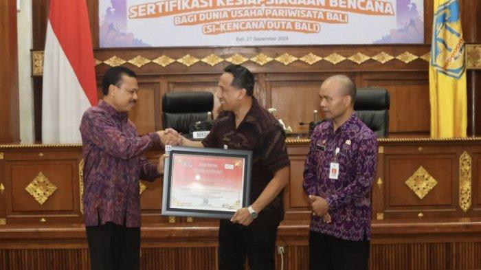 SERAHKAN SERTIFIKAT – Sekda Pemerintah Provinsi Bali Dewa Made Indra menyerahkan sertifikat siap siaga bencana ke industri pariwisata di Denpasar, Jumat (27/9). Dari 498 hotel berbintang di Bali, baru 106 hotel berbintang yang menerima sertifikat kesiapsiagaan bencana.
