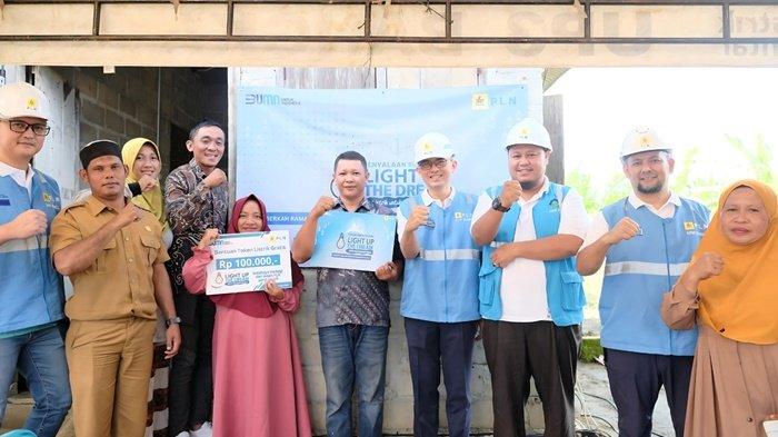 TERHARU -- Bapak Bukhari (hem pendek batik di tengah) beserta Istri (baju pink), merasa sangat bersyukur dan terharu atas bantuan Light Up The Up The Dream PLN yang telah melakukan penyambungan listrik gratis di rumahnya.