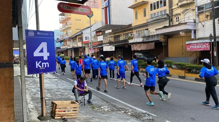 DOKUMENTASI PELARI -- Fotografer lepas mendokumentasikan para pelari QRIN RUN 5K Bank Indonesia Babel di titik Km 4 rute di dekat Kelenteng Kwan Tie Miaw, Pangkalpinang, Minggu (27/7/2025).