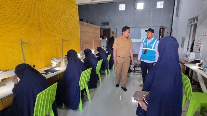 Manajer APKU PLN UIW Babel, Zulkarnain (rompi biru) bersama Lurah Kacang Pedang, Ikhsan Sugiarto meninjau pelatihan menjahit santriwati Pesantren Ziir Hubais dengan menggunakan peralatan jahit bantuan TJSL PLN .