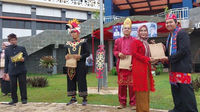 DIREKTUR Politala Dr Hj Mufrida Zein SAg MPd menyerahkan hadiah kepada peserta upacara Hardiknas yang berbusana adat paling ciamik.