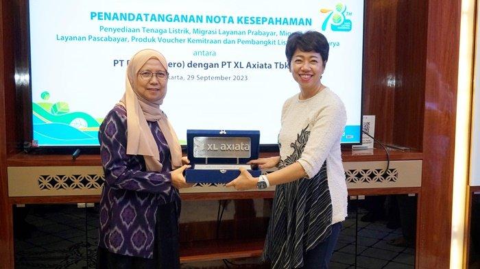 Direktur & Chief Enterprise and Corporate Affairs Officer XL Axiata, Yessie D Yosetya (kanan), menyerahkan kenang-kenangan kepada Direktur Retail dan Niaga PLN, Edi Srimulyanti, setelah menandatangani kerja sama di Jakarta, Jumat (29/9/2023).