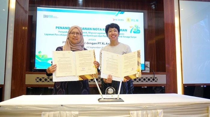 Direktur & Chief Enterprise and Corporate Affairs Officer XL Axiata, Yessie D Yosetya (kanan), dan Direktur Retail dan Niaga PLN, Edi Srimulyanti, menunjukkan dokumen kerja sama yang telah ditandatangani, Jumat (29/9/2023).