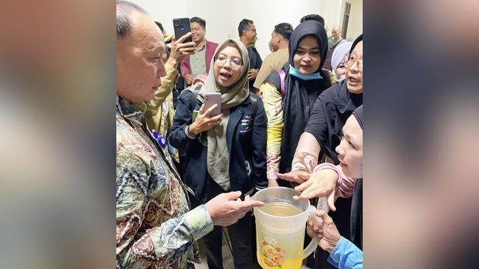 Emak-emak sodorkan teko berisi air leding keruh, protes ke Direktur Utama (Dirut) PT Air Minum (PTAM) Intan Banjar, Syaiful Anwar, saat di Gedung DPRD Provinsi Kalimantan Selatan, Kamis (3/8/2023). Bahkan ada pelanggan yang mengancam berhenti jadi pelanggan hingga dijawab Dirut supaya lapor dan tulis nama bagi yang ingin pindah jadi pelanggan.