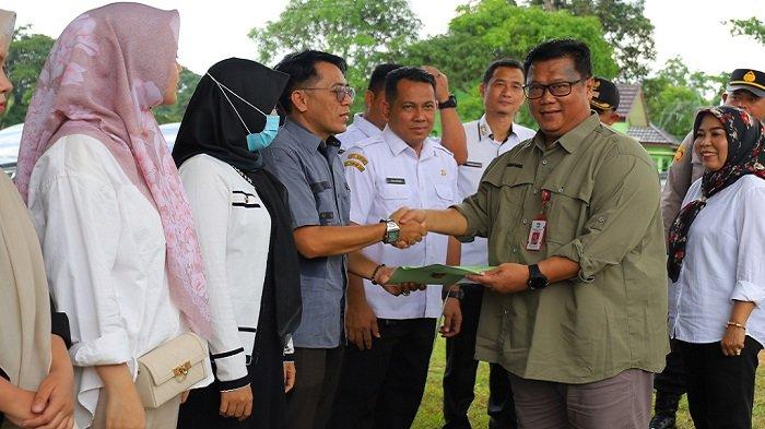 KEPALA Dinas PUPRP Tala Syahkril Hadrianadi menyerahkan sertifikat program PTSP kepada perwakilan warga di Kecamatan Kintap, Rabu (6/11).