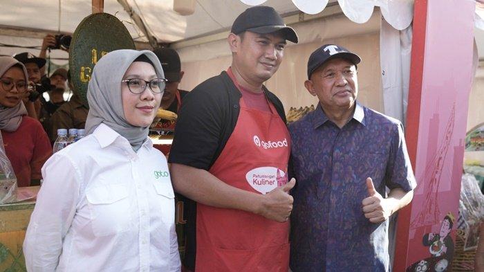 Perwakilan Mitra Usaha GoTo, dari GoFood, Sulistyono - pemilik kuliner Juara Lokal Solo Leker Gajahan Bapak Fathoni Jr. (tengah) berfoto bersama di sela-sela kunjungan Menteri Koperasi dan UKM, Teten Masduki, yang turut didampingi oleh Director of External Affairs GoTo, Nila Marita pada Perayaan Hari UMKM Nasional 2023.