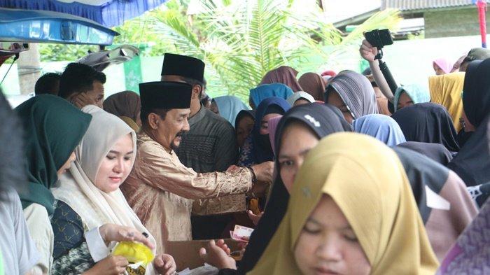 PASAR MURAH - Pj Bupati Tala H Syamsir Rahman dan Pj Ketua TP PKK Tala Hj Rizki Yulia Syamsir Rahman turut membantu menjualkan sembako murah, Sabtu (30/3).