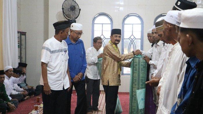 KARPET - Pj Bupati Tala H Syamsir Rahman menyerahkan karpet sholat pada Safari Ramadhan di Desa Bumi Harapan, Sabtu (30/3).