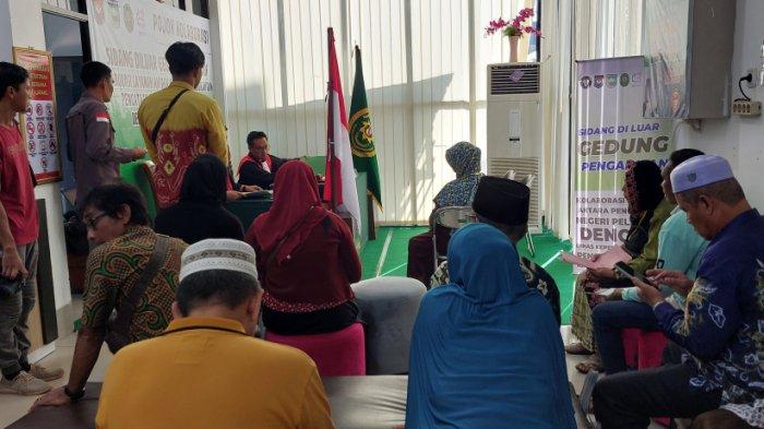 SUASANA sidang di luar gedung pengadilan bertempat di kantor Dinas Dukcapil Tala, Jumat (26_7) pagi. Belasan peserta sidang antusias menunggu giliran sidang.,