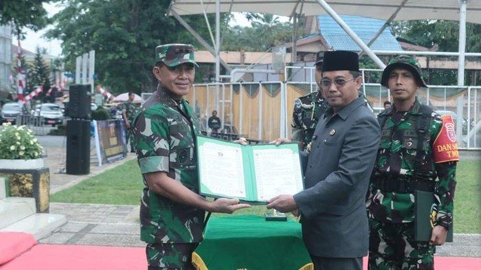 Serah terima hasil pelaksanaan kegiatan pembangunan fisik program TMMD  oleh Mayjen TNI Tri Budi Utomo kepada Pj Bupati HSS Endri, pada penutupan TMMD ke 121 Kodim 1003 HSS.