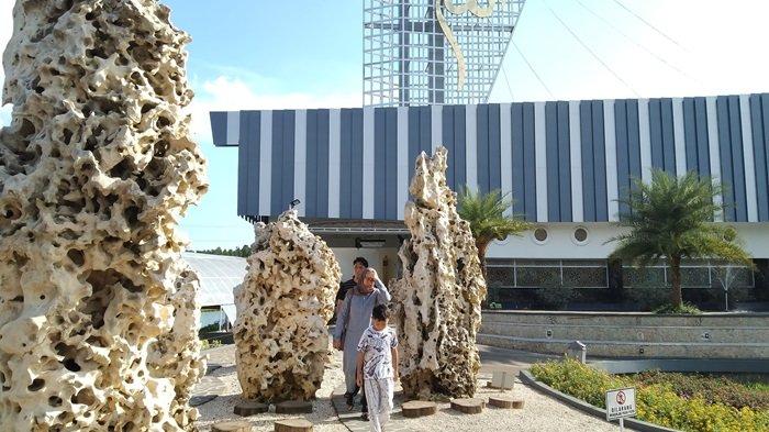 Pengunjung melintas di antara batu tulang berwarna putih yang menyerupai batu karang di halaman Masjid As-Shodiqin di Rest Area As-Shodiqin di Desa Madura, Kecamatan Wanareja, Kabupaten Cilacap. Masjid berbentuk kapal ini menjadi daya tarik pemudik yang melintasi Jalur Selatan Jawa Tengah.