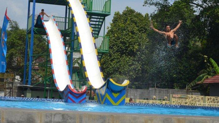 Pengunjung Owabong Waterpark Purbalingga menikmati wahana prosotan air, Minggu (1/5/2022).