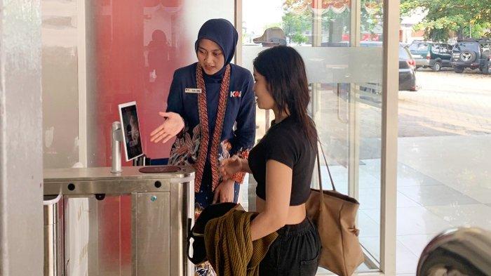 Petugas memandu calon penumpang memanfaatkan fasilitas face recognition boarding gate di Stasiun Pekalongan, Jumat (16/8/2024).