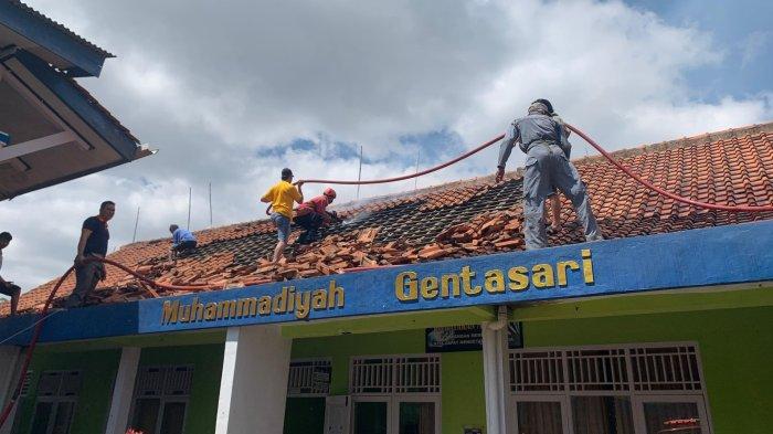 Petugas Pos Damkar Kroya dibantu relawan damkar dan warga memadamkan api dalam insiden kebakaran yang terjadi di SMP Muhammadiyah 02 Kroya, Cilacap, Minggu (18/8/2024).