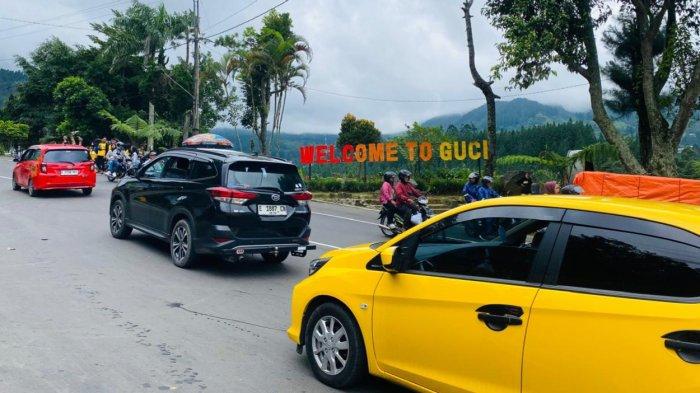 Kendaraan mengular di akses pintu utama Daya Tarik Wisata (DTW) Guci, Kabupaten Tegal, Jawa Tengah. Kendaraan antre masuk ke kawasan wisata pada Minggu (5/1/2025).