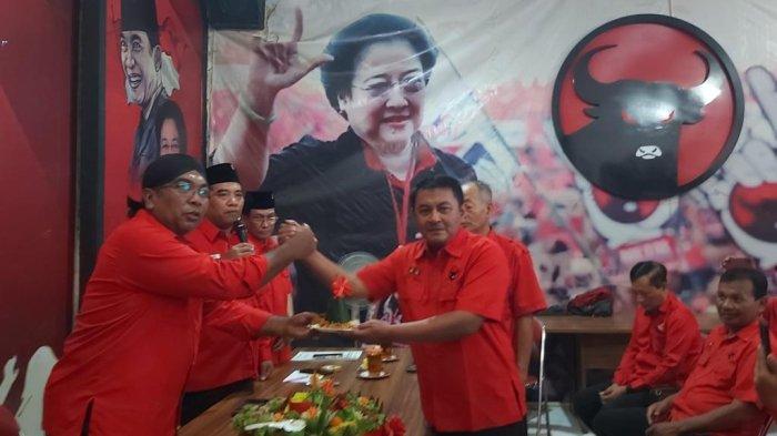 Ketua DPC PDIP Kota Tegal, Edy Suripno (kiri) memberikan potongan tumpeng kepada Desk Pilkada, Kusnendro sebagai simbolis resminya pembukaan pendaftaran dan penjaringan bakal Calon Wali Kota dan Calon Wakil Wali Kota (Cawalkot dan Cawawalkot) Tegal 2024, Rabu (1/5/2024).