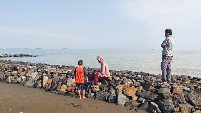 Pengunjung menikmati Pantai Pulo Kodok di Kota Tegal dari tanggul laut, Minggu (10/9/2023). Pembangunan tanggul dari bebatuan ini merupakan bantuan dari Komisi 3 DPRD Kota Tegal senilai Rp200 juta.