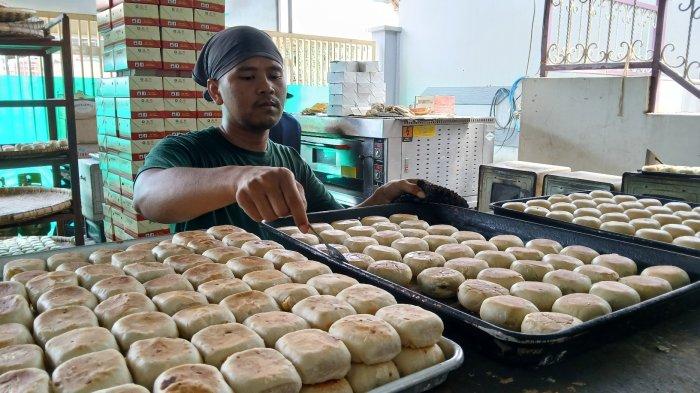 Seorang karyawan meletakkan kue latopia yang sudah matang di atas oven di Toko Kue Pia Keysha Jalan Semarang No 3 Kelurahan Debong Tengah, Kota Tegal, Selasa (26/11/2024).