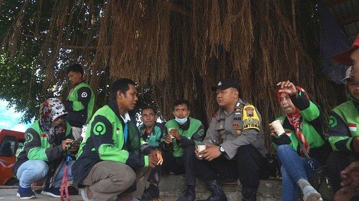 Anggota Bhabinkamtibmas Kelurahan Kauman Bripka Suhartono mendengar curhat dari driver ojek daring lewat progran Ngucur Pak di Alun-alun Batang, Rabu (5/7/2023).