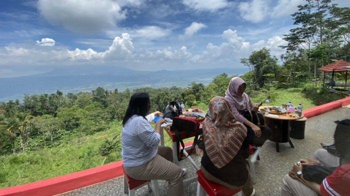 Pengunjung menikmati makanan serta pemandangan alam di Sitaring View, Dusun Puwono, Desa Kemambang, Kecamatan Banyubiru, Kabupaten Semarang, Jumat (5/1/2024) siang. Tempat wisata di lereng Gunung Telomoyo ini menjadi destinasi baru yang tengah dikembangkan Pemdes Kemambang.