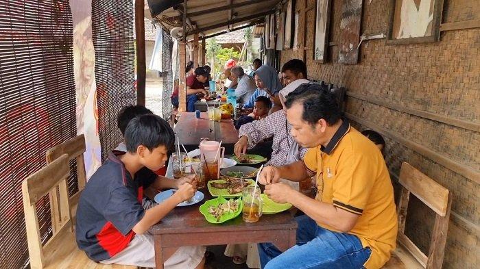 Pengunjung menyantap hidangan di warung makan Pak Gondrong di Desa Robayan, Kecamatan Kalinyamatan, Kabupaten Jepara, Jateng, Selasa (18/6/2024). Entog asap sambel mowo menjadi andalan di warung makan ini.