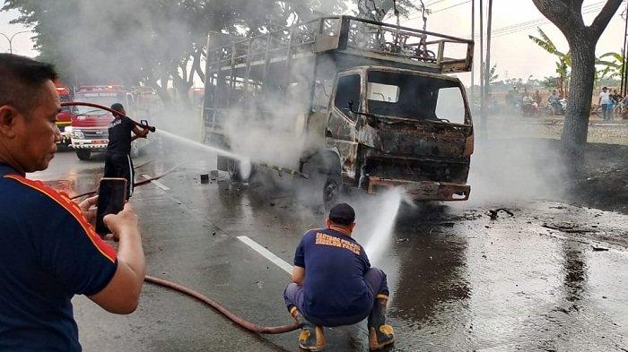 Petugas Pemadam Kebakaran Demak berusaha memadamkan Api yang membakar truk pengangkut sepeda listrik di Jalan Demak menuju Kabupaten Kudus, Minggu (17/9/2023).