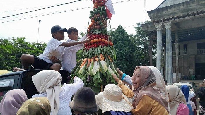 Warga berebut gunungan yang diarak dalam acara Pager Gesek kegiatan sedekah bumi di Desa Srikandang, Kecamatan Bangsri, Kabupaten Jepara, Rabu (3/7/2024).