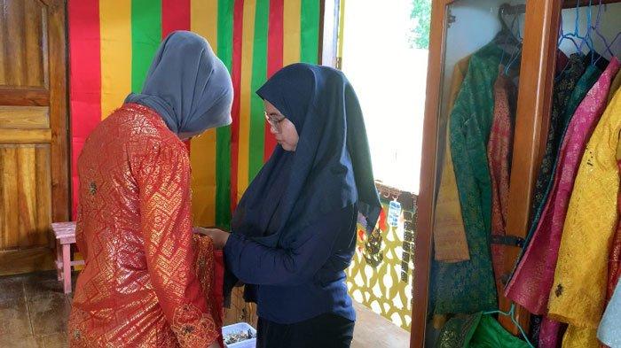 Pengunjung saat coba baju adat di Balai Adat Indera Perkasa di Pulau Penyengat, Tanjungpinang, Kepri