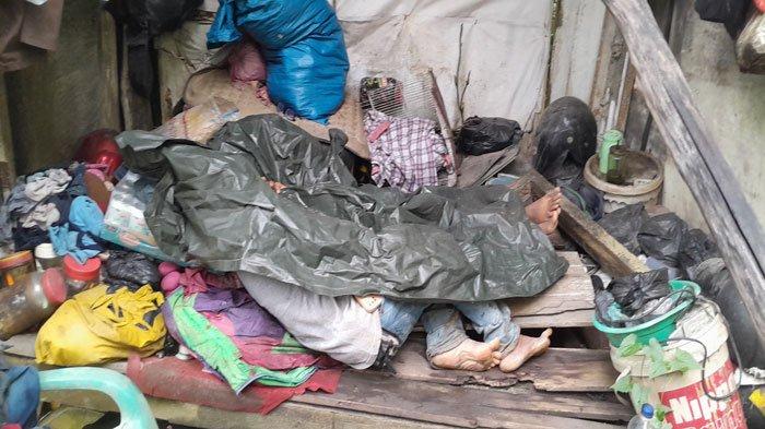 Sriariyanto alias Heri (45) dan anaknya Adit (12), warga Bintan, tidur berselimut jas hujan di gubuk reyot, tempat mereka tinggal, Rabu (17/4/2024)