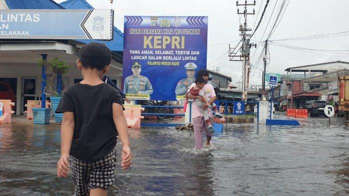 BANJIR ROB - Dua anak asyik bermain air di lokasi jalan tergenang akibat banjir rob di RE Martadinata dan jalan Merdeka, Tanjunguban, Kecamatan Bintan Utara.