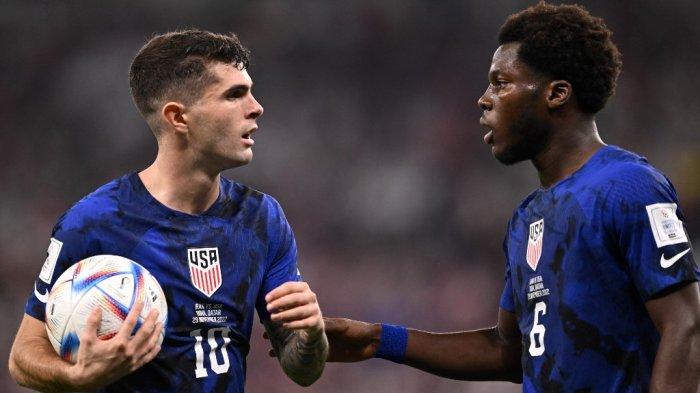 Striker Timnas Amerika Serikat Christian Pulisic (kiri) bicara dengan rekannya Yunus Musah saat pertandingan melawan Iran di Piala Dunia 2022 Qatar, 29 November 2022.