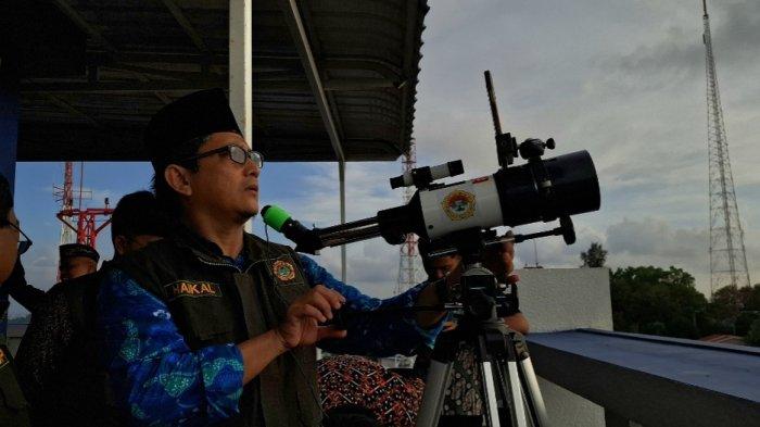 PANTAU HILAL - Seorang pria tengah mengatur teropong bintang untuk memantau hilal 1 Ramadan 1446 H, Jumat (28/2/2025) petang.