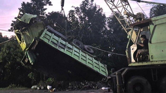 EVAKUASI TRUK MAUT - Petugas mengoperasikan kendaraan crane untuk mengevakuasi truk yang terjun ke sungai setelah menabrak mobil pikap dan pemotor di jalur Probolinggo-Lumajang, Selasa (27/5/2025). Dalam kecelakaan menonjol ini ada 4 orang meninggal dunia.