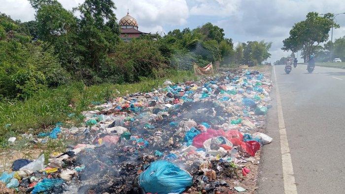 SAMPAH DIBAKAR - Tumpukan sampah di jalan trans Barelang Kota Batam, dibakar baunya ganggu wisatawan ke Jembatan Barelang, Minggu (5/1/2025).